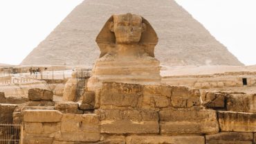 Travelers on the best Egypt tours exploring the Pyramids of Giza with the Sphinx in the background